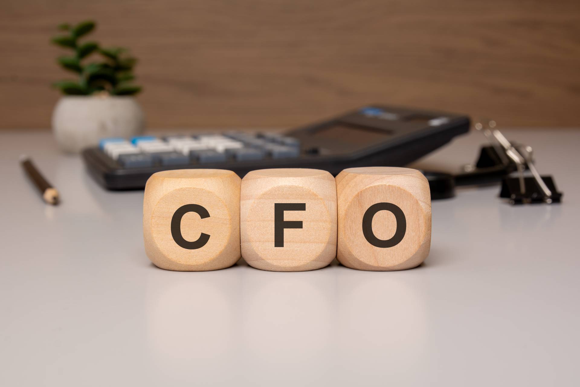 wooden-cubes-with-cfo-letters-desk-with-calculator-background